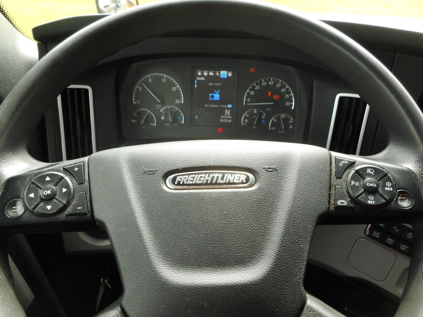 Freightliner Cascadia steering wheel and instrument cluster with center display showing speedometer and gauges