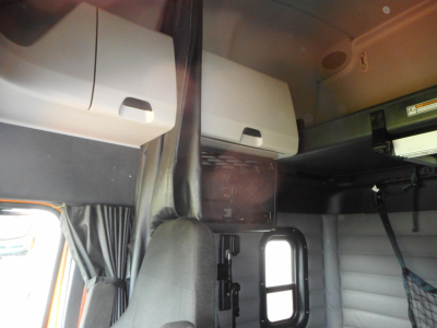 Cab interior of a 2022 Freightliner Cascadia showing overhead storage compartments and sleeper area.