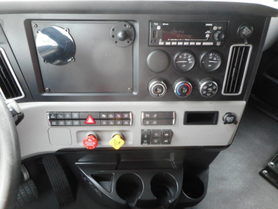 Dashboard of a 2022 Freightliner Cascadia showing dual gauges, controls, ignition, and cup holders in the lower console.
