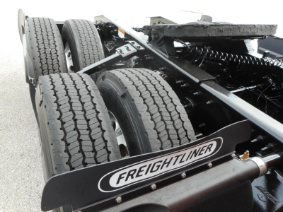 Freightliner Cascadia tractor rear chassis showing dual rear wheels and Freightliner mudflap logo.