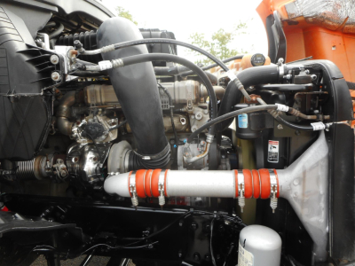 Freightliner Cascadia engine bay showing turbocharger, hoses, intercooler piping, coolant reservoir, and air intake components.