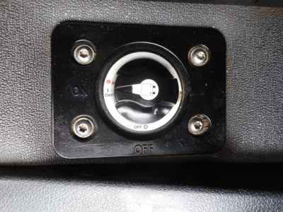 Dashboard switch panel with circular ignition-like knob showing ON/OFF markings in a Freightliner Cascadia interior image.