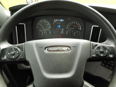 Freightliner Cascadia steering wheel and instrument cluster with center display showing speedometer and gauges