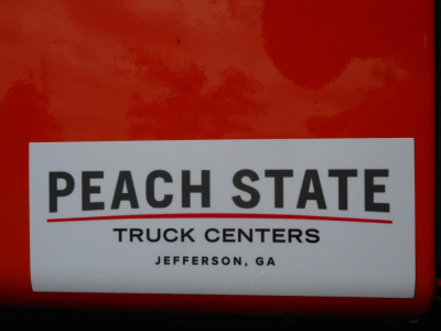 Freightliner Cascadia engine bay label showing Peach State Truck Centers sticker
