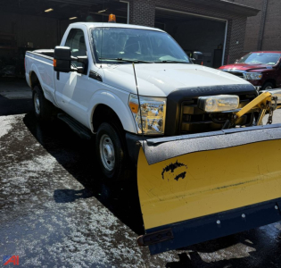 2015 Ford F-250 Super Duty pickup with plow showing front bumper snow plow and warning light, white cab, side mirrors, and raised plow blade.
