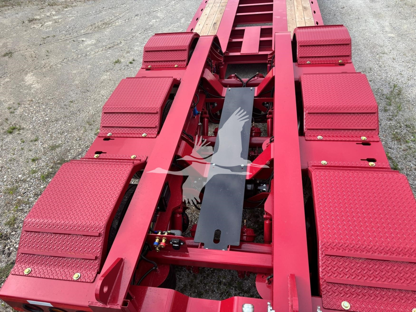 Fontaine 55 LCC lowboy trailer chassis with red diamond plate fenders and steps, view of frame and components