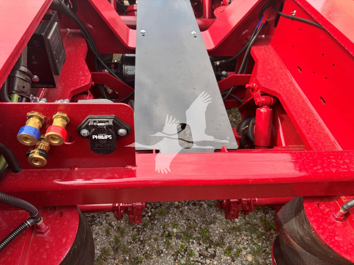 Fontaine trailer chassis with red painted steel frame showing hydraulic components, valves, and a central steel beam.