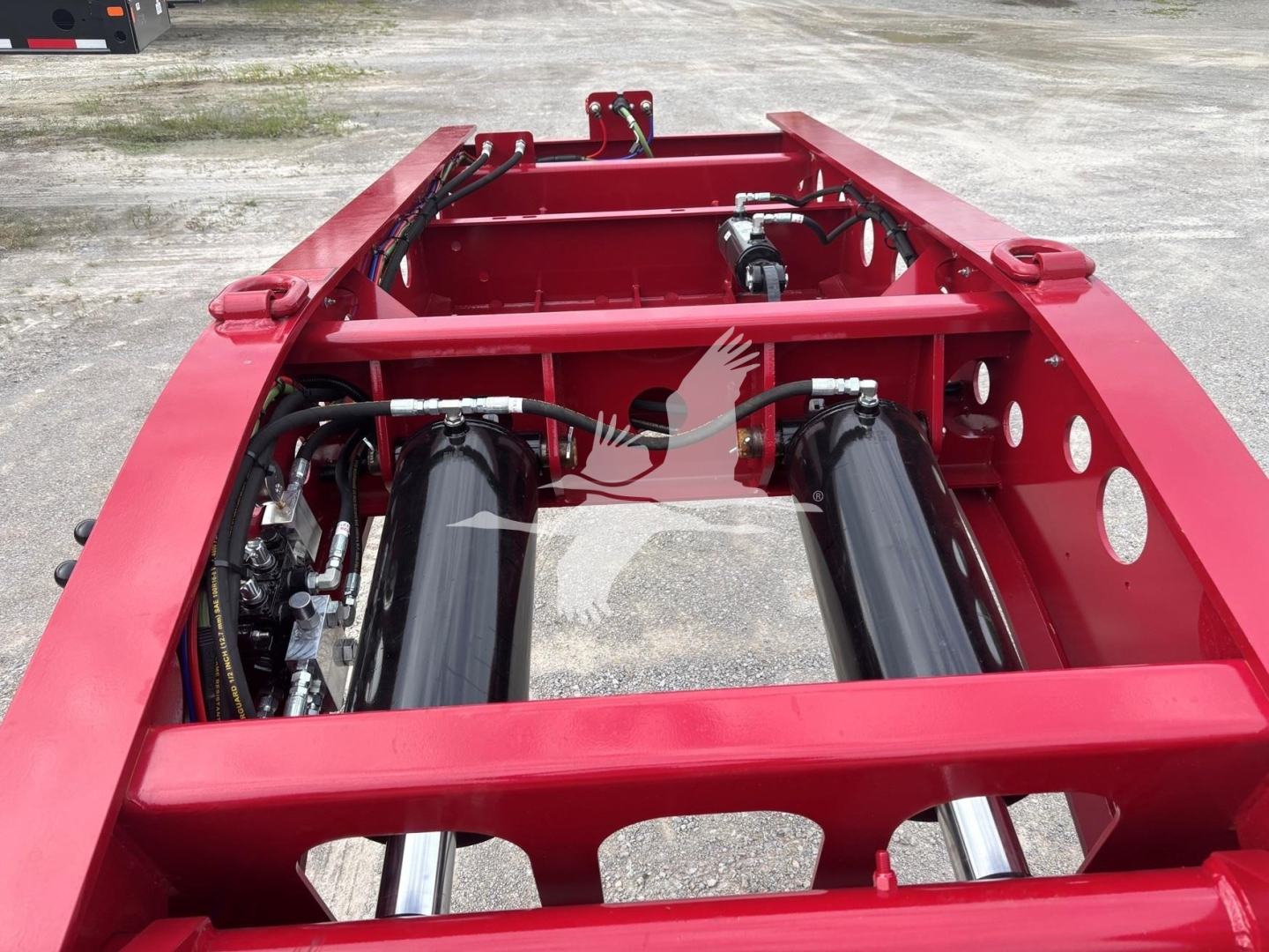 Fontaine 55 Lcc lowboy trailer frame showing hydraulic lines and dual airride/buttress components with red chassis.