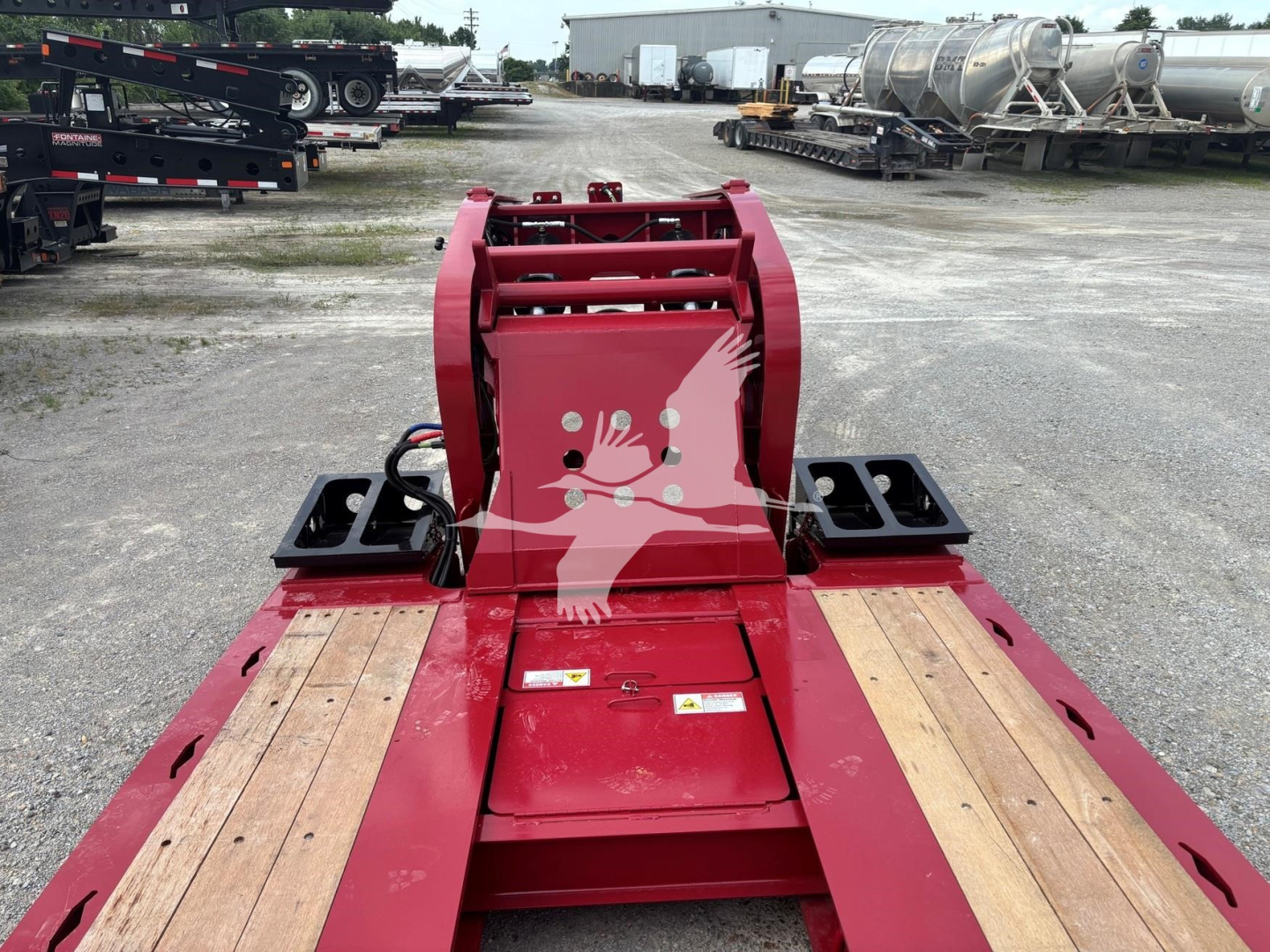 Red Fontaine 55 Lowboy trailer hitch attachment and wooden deck with black mounting brackets.