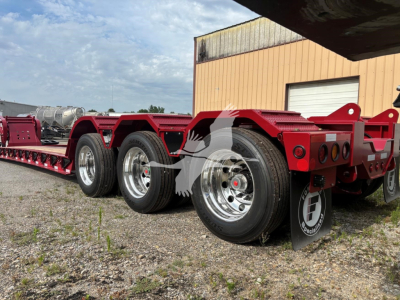 Fontaine lowboy trailer chassis with multiple axles and red paint, chrome wheels, and black mudflaps; appears new with VIN 13NE53302V35A7287 and stock V35A7287.