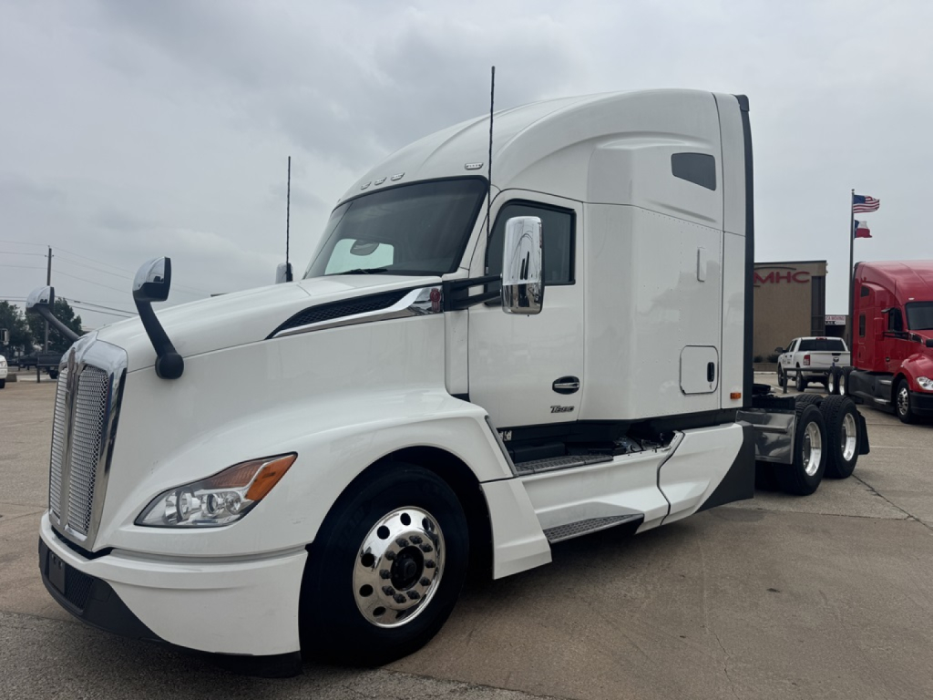 Kenworth T680 tractor unit in white from a side-front view showing cab and front wheel, no visible text on components.