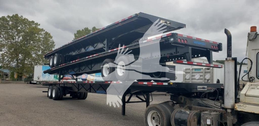 Trailer: 2024 Wabash Steel Air Slider flatbed trailer in side view with dual axles and landing gear, showing top deck and steel frame