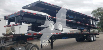 Wabash steel air slider trailer in stacked position showing flatbed with multiple axles and hydraulic lift with visible tires and frame