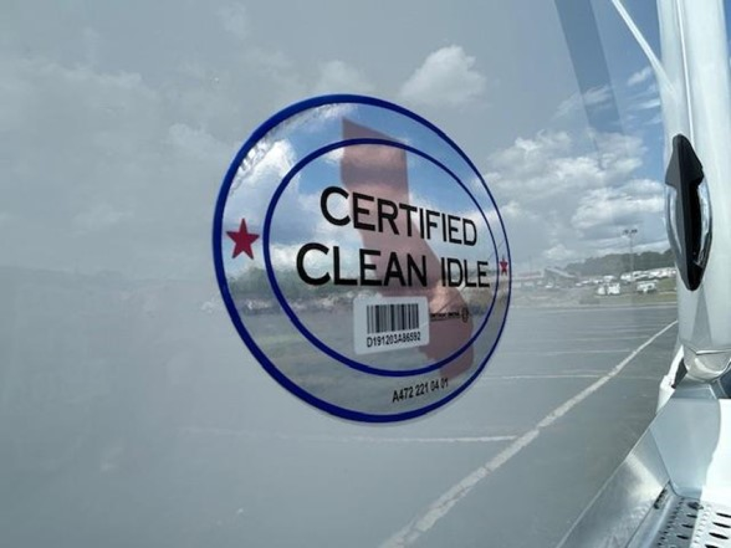 Sticker reading CERTIFIED CLEAN IDLE on the side window of a Freightliner Cascadia truck