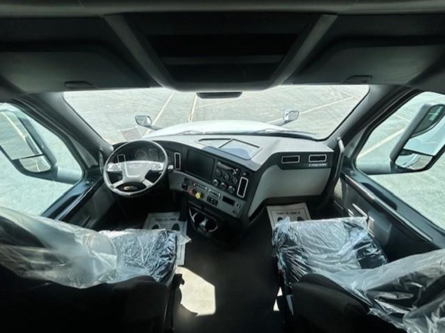Truck cab interior view of a 2022 Freightliner Cascadia 126 with steering wheel and dashboard visible.