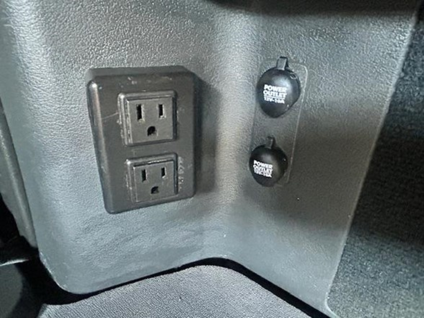 Truck cab interior showing two-prong power outlets and two power outlets labeled ‘Power Outlet’ in a Freightliner Cascadia 126 dash area.