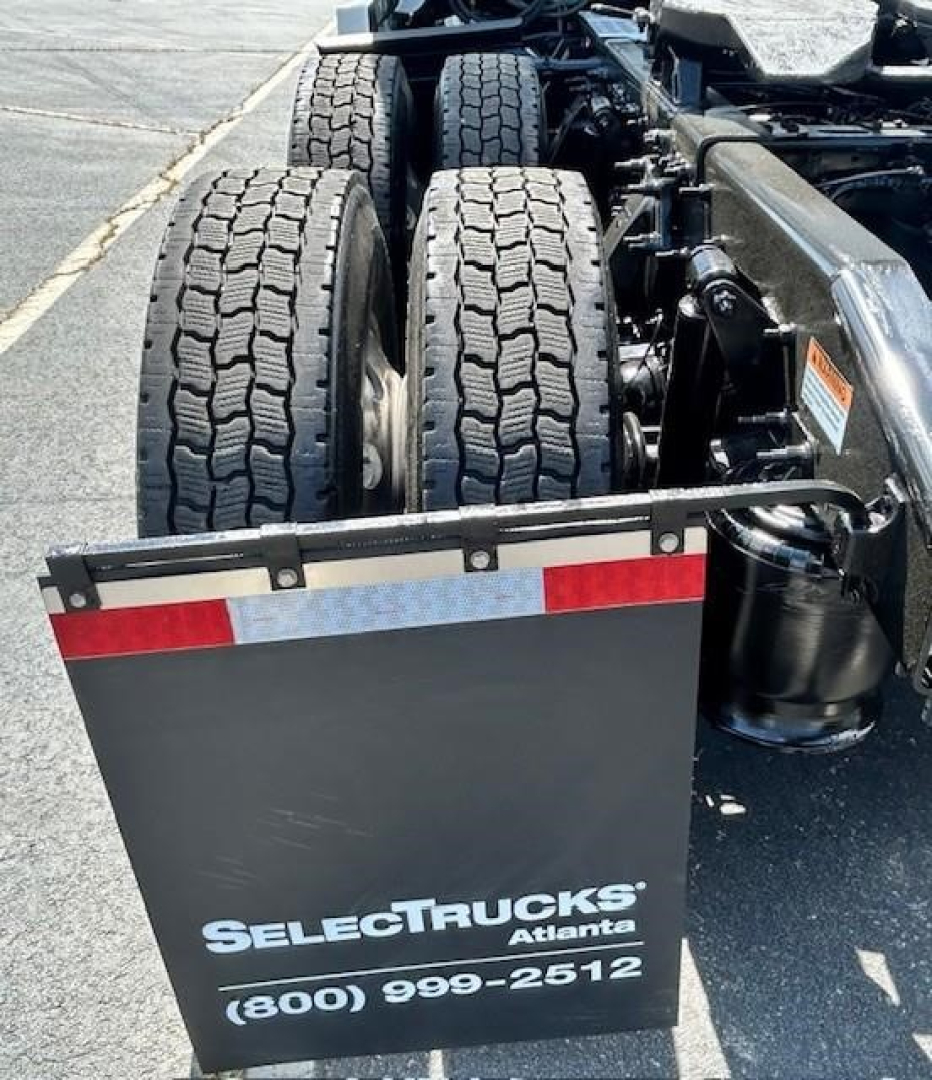 Rear view of a Freightliner Cascadia truck showing dual rear axles and mudflaps with Select Trucks Atlanta branding and contact number.