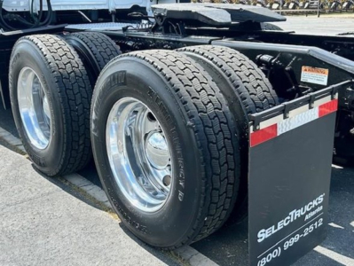 Freightliner Cascadia 126 rear dual axle wheels with chrome rims and black mud flaps showing Select Trucks branding.