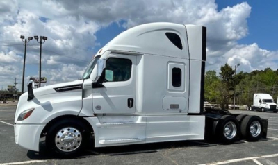 Side view of a white Freightliner Cascadia 126 tractor-trailer cab with sleeper, showing left profile and wheels.