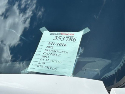 Tag on windshield showing stock number 353786, VIN MU1016, 2022 Freightliner Cascadia 126, DD15 engine, DT-12 auto, 2.79 axle ratio.