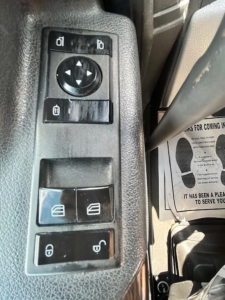 Truck interior panel with window and mirror control switches visible