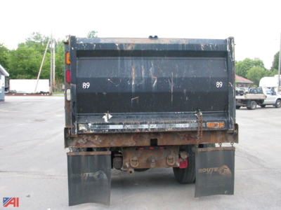 Dump truck bed rear showing tailgate with rutting and hydraulic system visible, International 7400 dump truck.