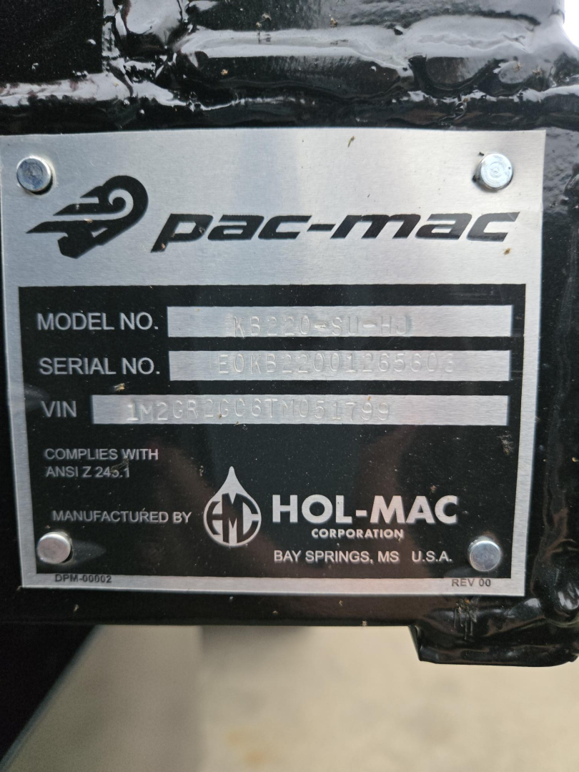 Plate showing Pac-Mac model number, serial number, and VIN on Mack GR64B chassis plate. Text includes PAC-MAC logo, MODEL NO., SERIAL NO., VIN 1M2GR2GC6TM051799, manufactured by HOL-MAC CORPORATION, BAY SPRINGS, MS, USA.