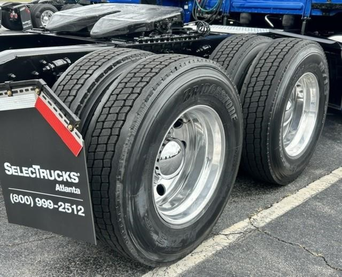 Conventional sleeper Freightliner Cascadia 126 rear dual rear axles with dual tires and chrome wheels; SelecTrucks Atlanta plate and contact info visible on mudflap.