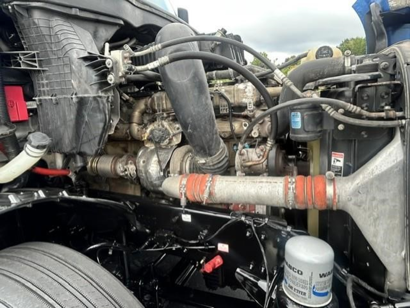 Freightliner Cascadia engine bay showing turbocharger, hoses, and oil filter