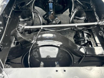 Front axle and suspension components of a Freightliner Cascadia 126 chassis showing solid differential housing and linkage, with visible driveshaft and surrounding underframe.