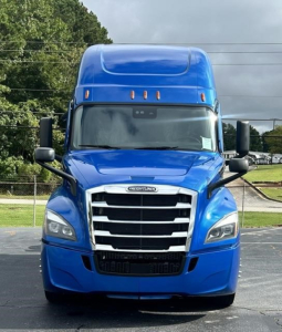 Freightliner Cascadia 126 front view showing bold chrome grille, blue cab, and sleeper top.