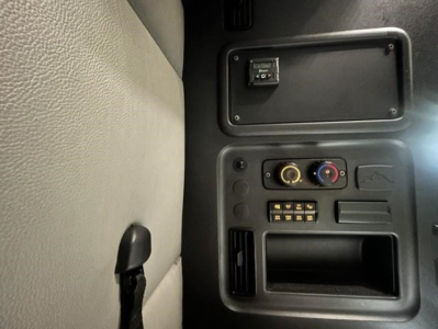 Cab interior of a 2022 Freightliner Cascadia 126 truck showing climate controls, switches, and storage area.