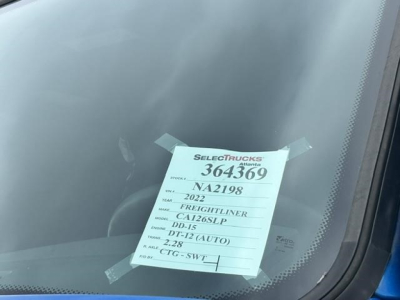 Vehicle tag on windshield of a 2022 Freightliner Cascadia 126 showing stock number 364369, VIN partially visible, and model details.