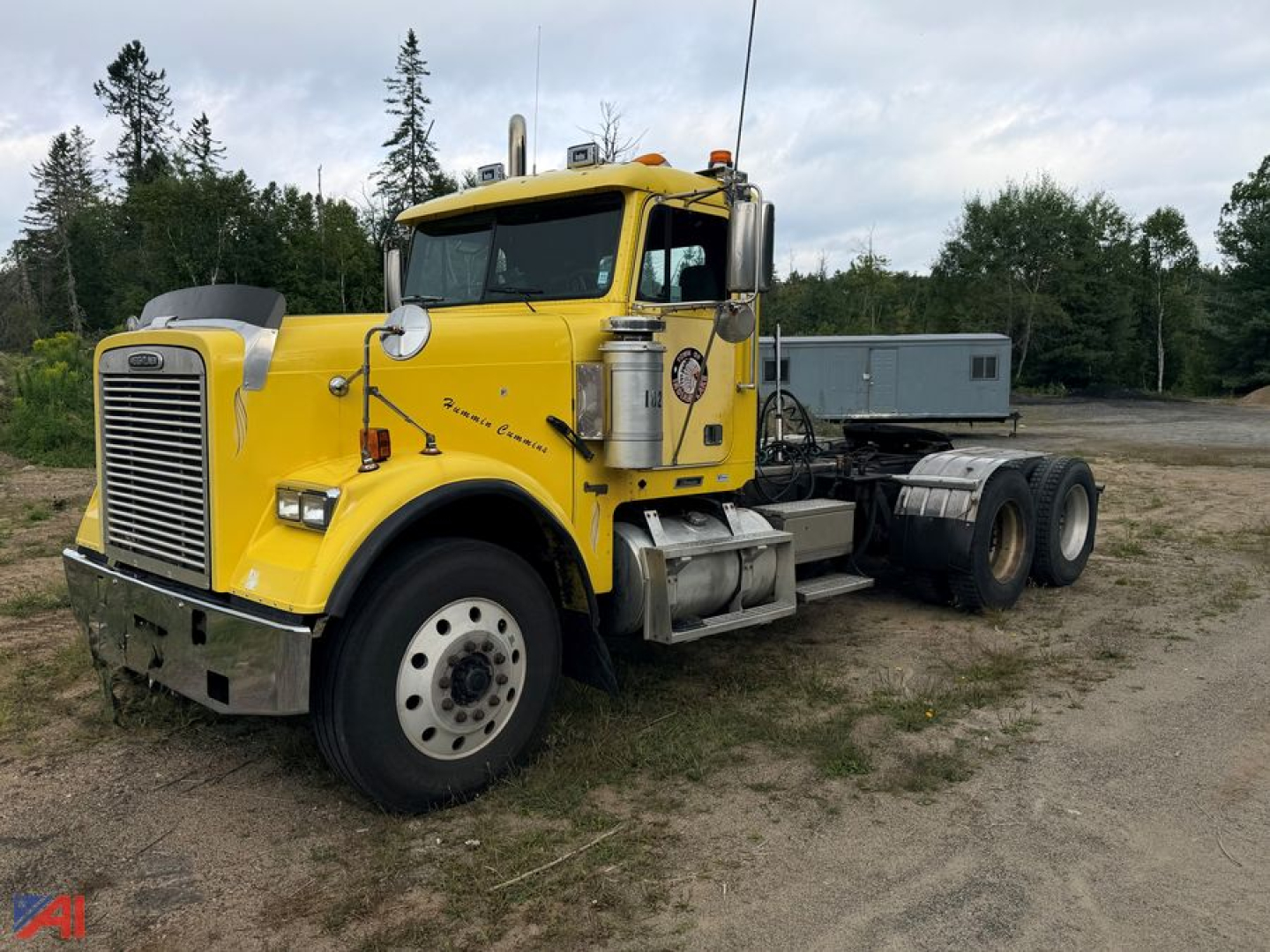 Yellow 2002 Freightliner FLD120 SD tractor shown in a side-angle view with a sleeper cab removed, front grille, dual rear axles, and chrome exhaust stacks.