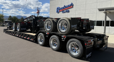 Trailer showing three-axle lowboy with dual rear axles and heavy-duty wheels, Alpha A120HDG-SF2 plate on deck.