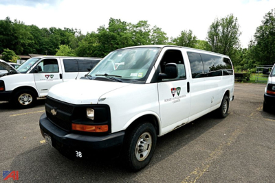 Chevrolet Express 3500 passenger van in white, side view showing 'Express' badge and 38 on front bumper.