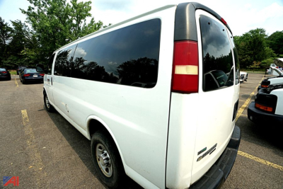 Chevrolet express passenger van rear-right view showing large windows and 12-passenger seating configuration