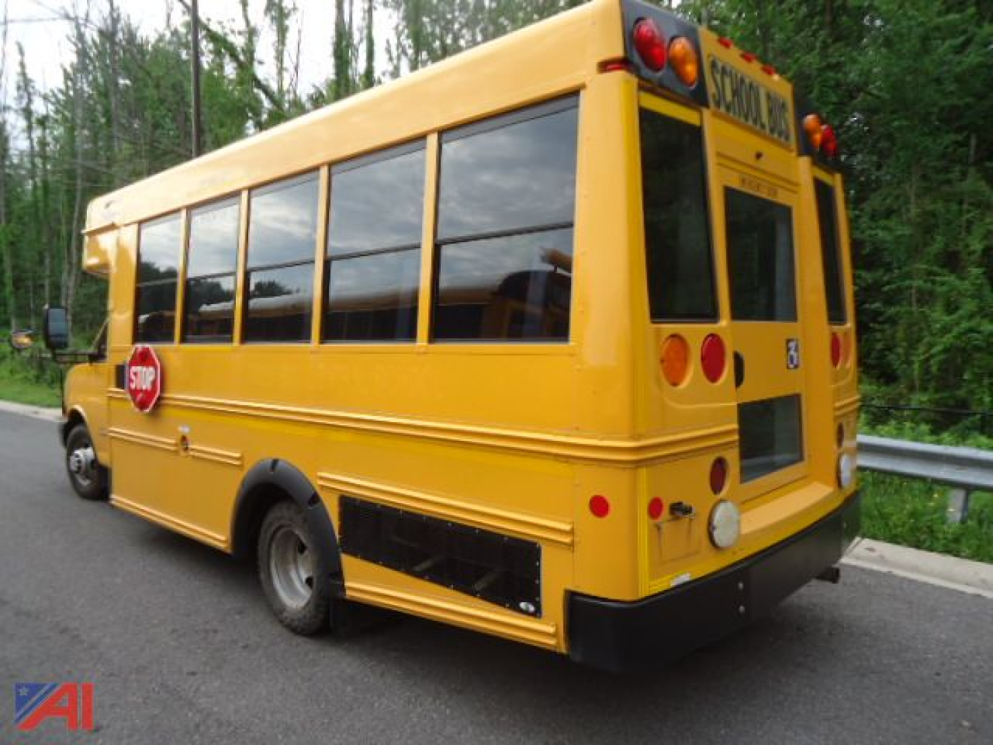 School bus rear/side view showing yellow Express 4500 Micro Bird with stop sign and school bus markings.