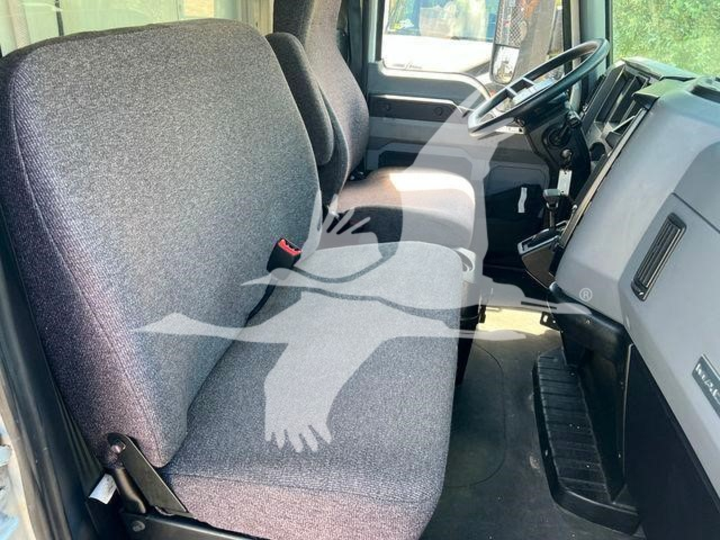 Truck cab interior showing front seats and dashboard of a Mack MD6. Visible text includes no explicit model badges in view.