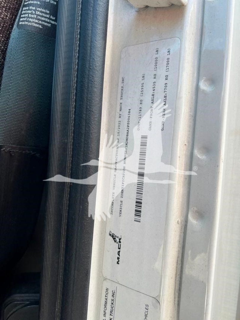 Sticker labels on door frame of a used 2023 Mack MD6 refrigerated truck showing VIN and stock information.
