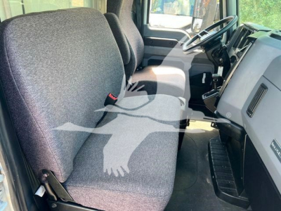 Truck cab interior showing front seats and dashboard of a Mack MD6. Visible text includes no explicit model badges in view.