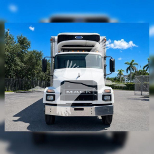Front view of a Mack MD6 refrigerated truck showing bold grille and cab with white paint and black accents.