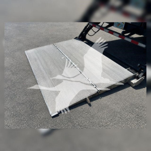 Platform/aluminum truck liftgate in a Mack MD6 refrigerated tractor showing a diamond-plate ramp with hinges and support braces.