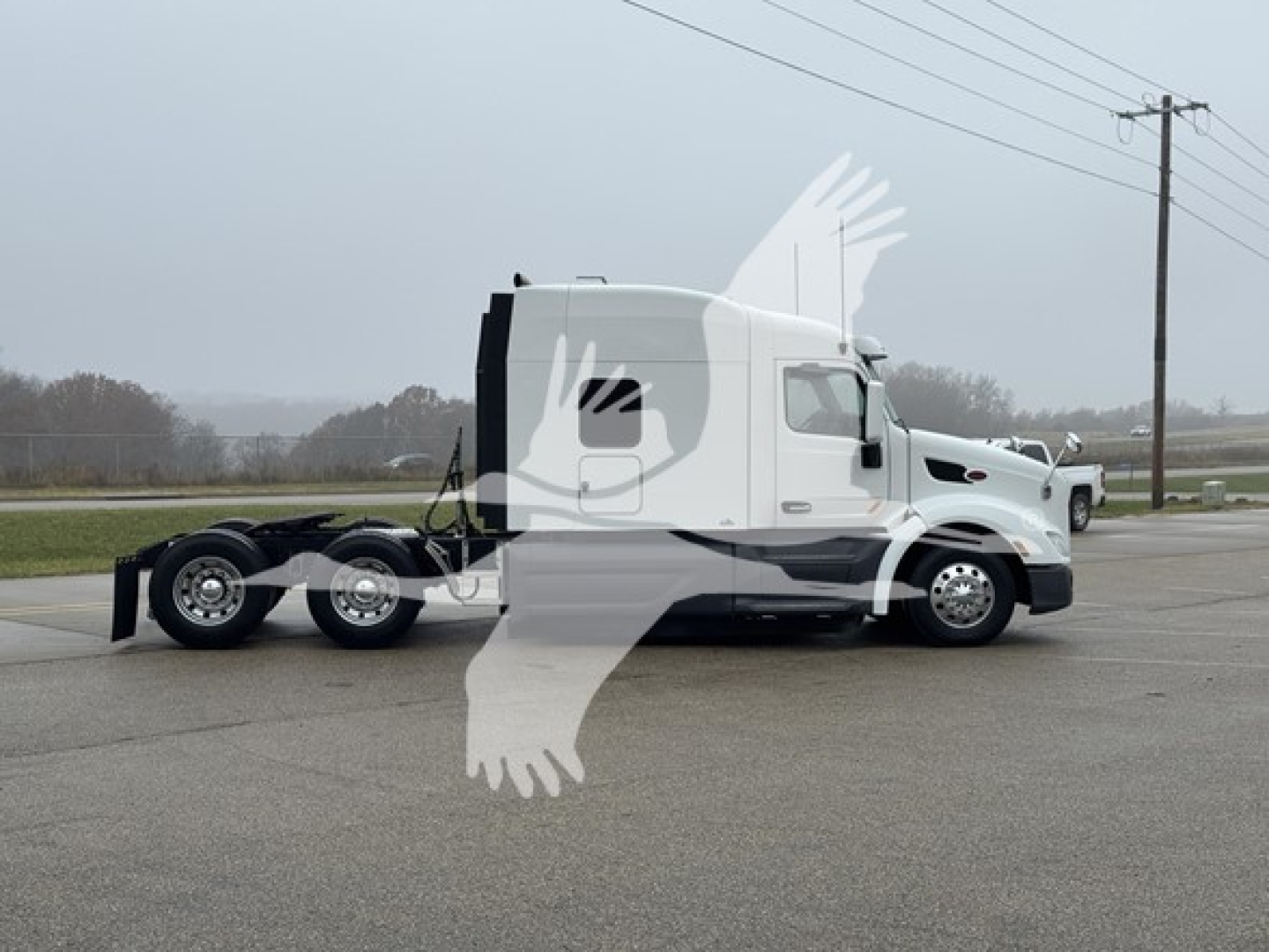 Conventional sleeper truck side view showing 2019 Peterbilt 579 with white cab and chassis, tag area, and side mirrors.