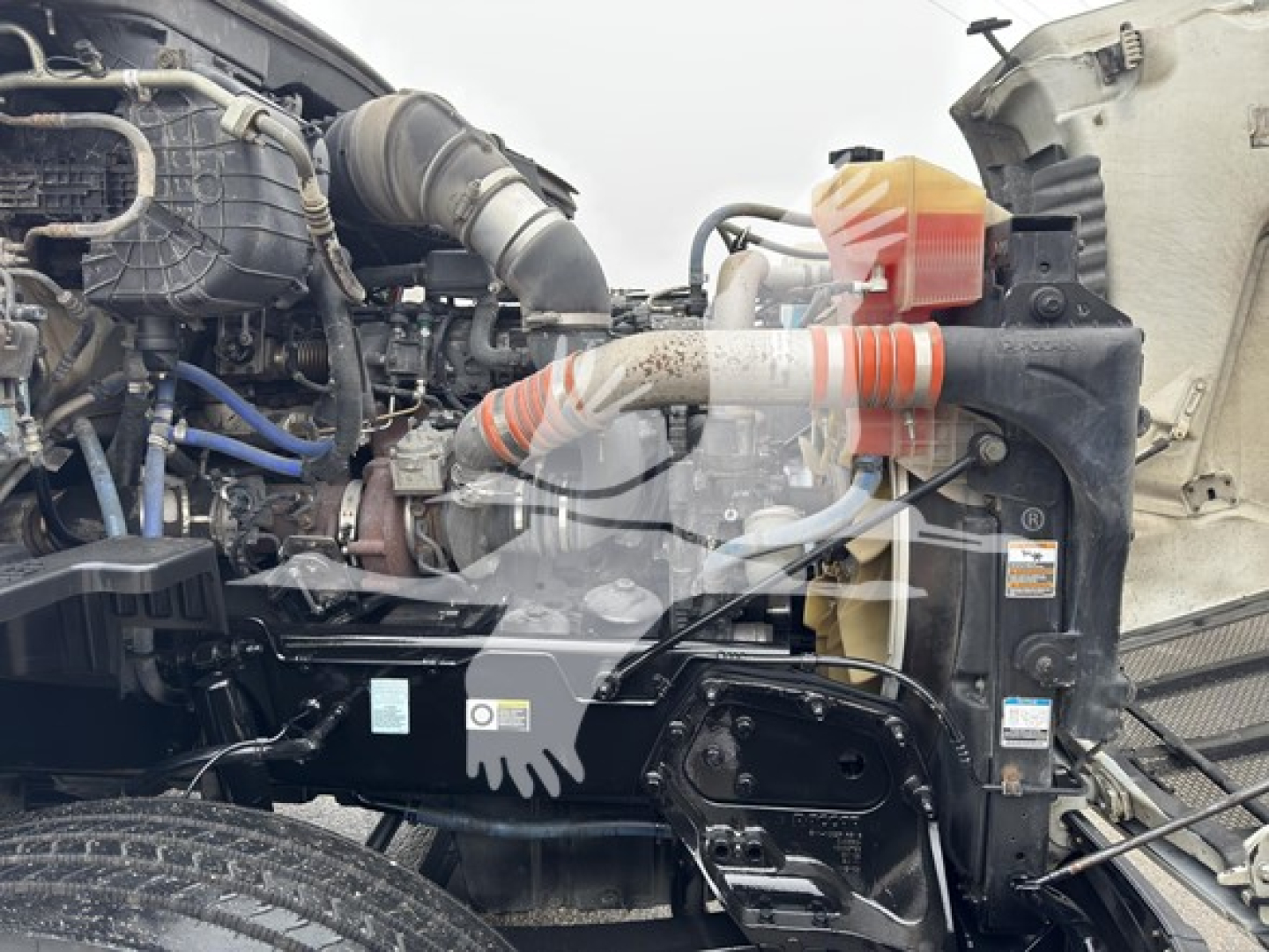 Peterbilt 579 engine bay with visible radiator, hoses, and coolant reservoir. Text and labels partially visible on components.