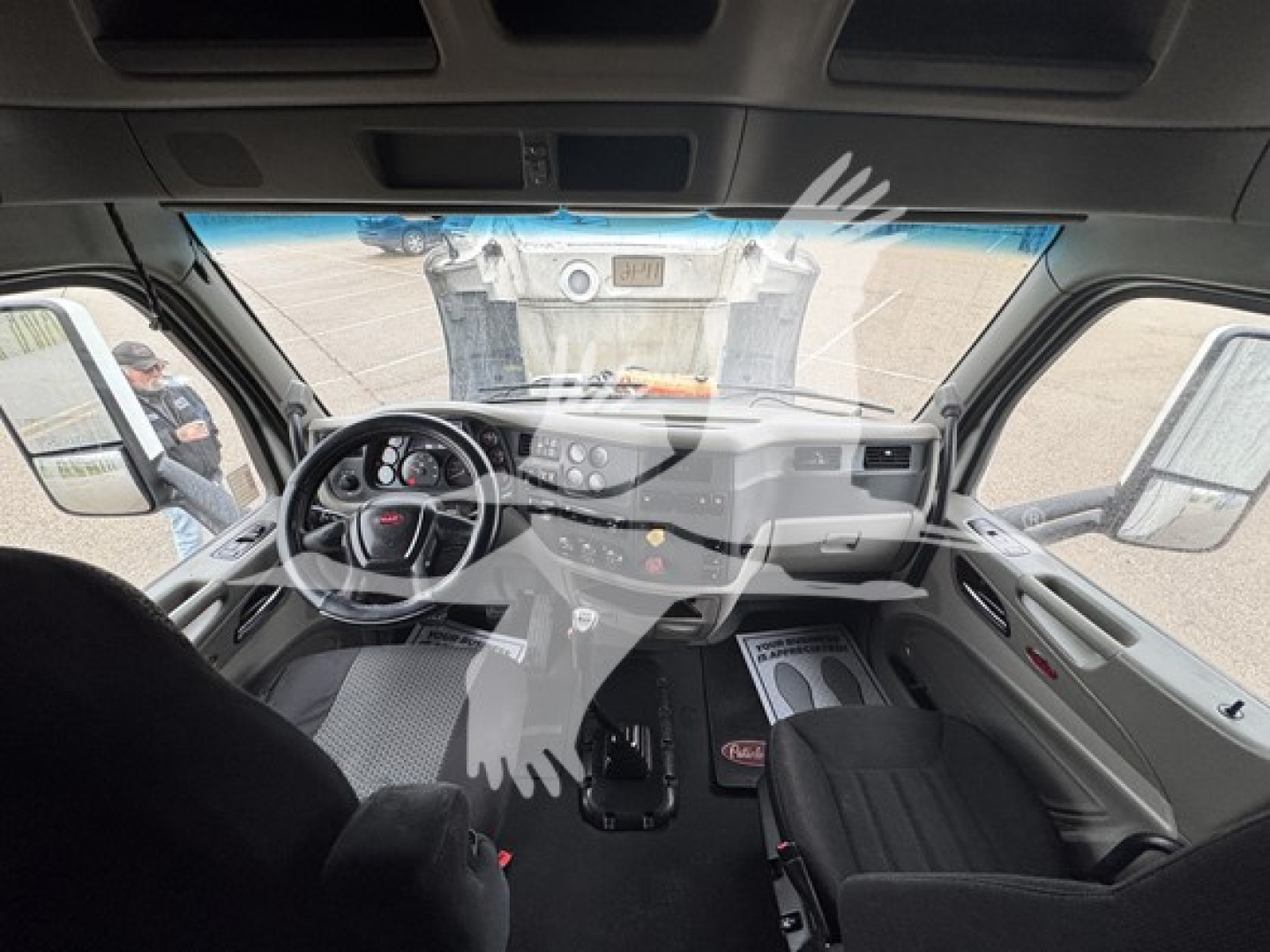 Cab interior view of a 2019 Peterbilt 579 conventional sleeper truck showing steering wheel, instrument cluster, center console, and dashboard with vents and controls.