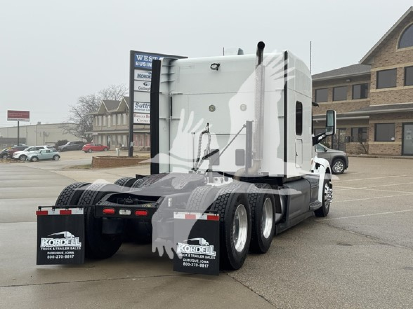 Peterbilt 579 sleeper cab tractor rear three-quarter view showing dual rear axles and mud flaps with Kordell logo.