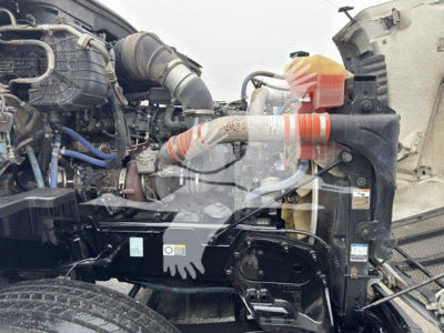 Peterbilt 579 engine bay with visible radiator, hoses, and coolant reservoir. Text and labels partially visible on components.