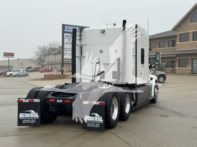 Peterbilt 579 sleeper cab tractor rear three-quarter view showing dual rear axles and mud flaps with Kordell logo.