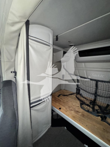 Interior sleeper cab of a Peterbilt truck showing bunk bed and storage netting.